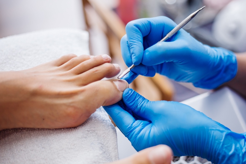 process-pedikura-domasnii-salonnyi-pedikur-uhod-za-nogami-i-nogtami-process-professional-nogo-pedikura-master-v-sinih-percatkah-delaet-pedikur — крупный размер.jpeg
